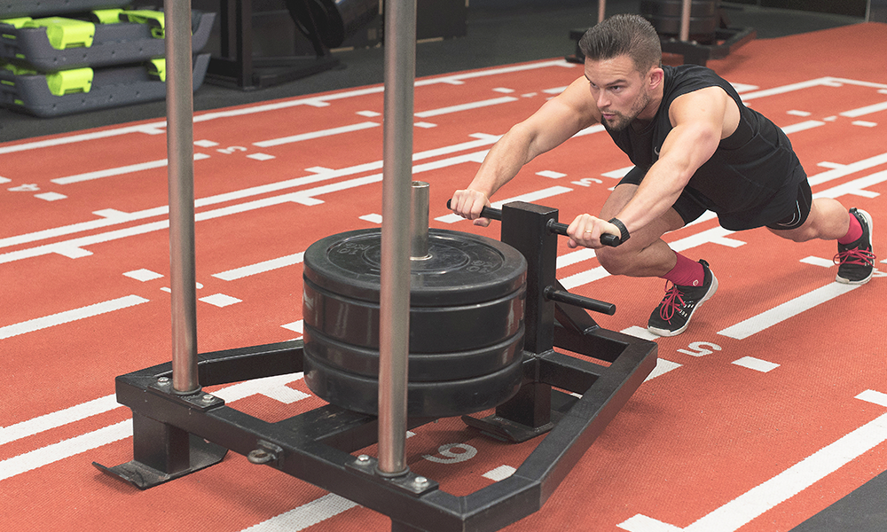 Danny pushes a sled at Third Space in Canary Wharf