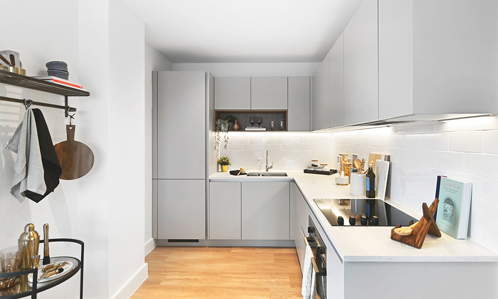 Image shows a modern fitted kitchen with white units and Zanussi appliances