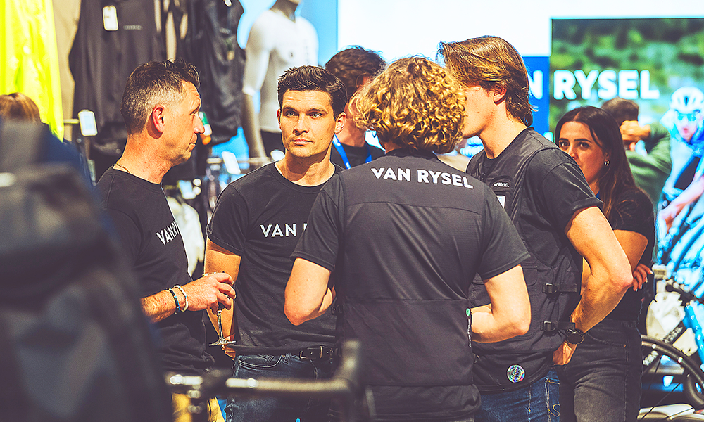 A group of men in Van Rysel T-shirts are seen standing in the new store