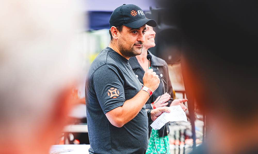 Image shows a man in a black baseball cap and T-Shirt with orange Far East Consortium logos – it's Bruno Almeida Santos, FEC's development director