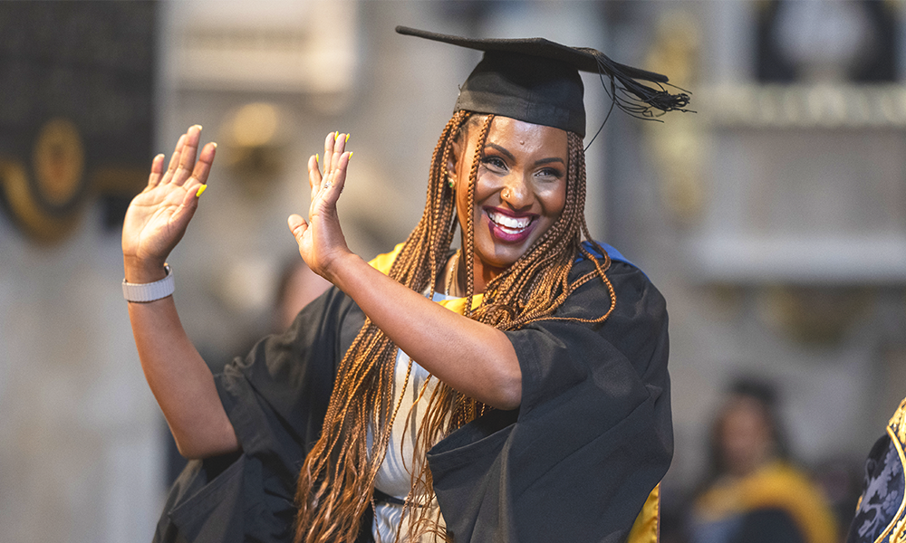A University Of Sunderland In London student in a mortar board and gown celebrates receiving her degree