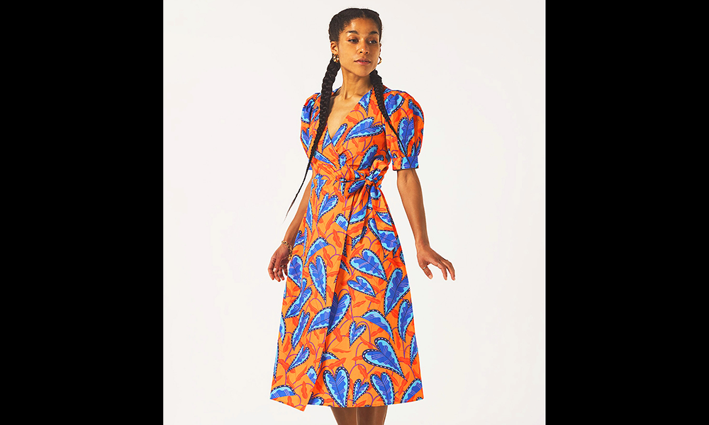 Image shows a woman wearing an orange and blue wrap dress falling to below her knees from Power Of Women
