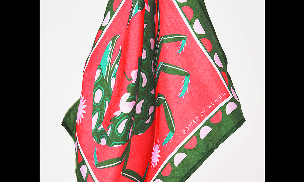Image shows a red and green silk scarf with a crab print, part of Leah Sams' Paradise Collection with a price of £25