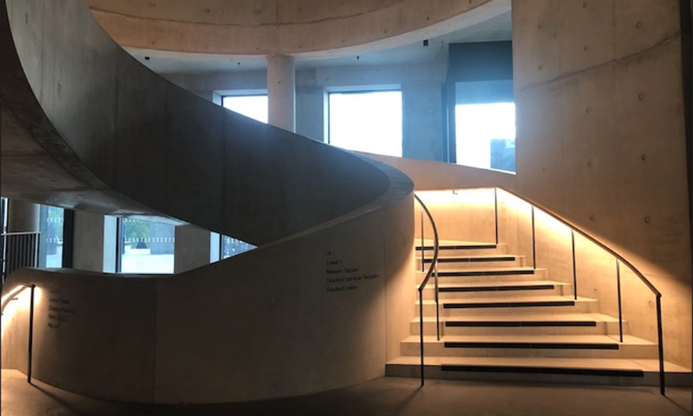 Image shows a curved concrete staircase at the London College Of Fashion in Stratford