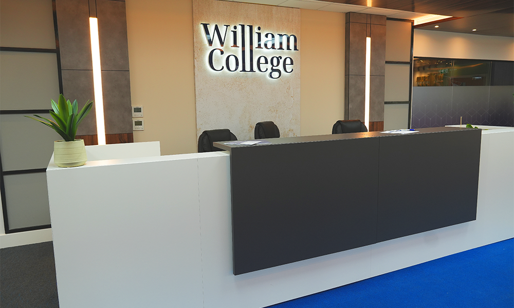 Image shows William College's reception area with LED lighting and a silver logo