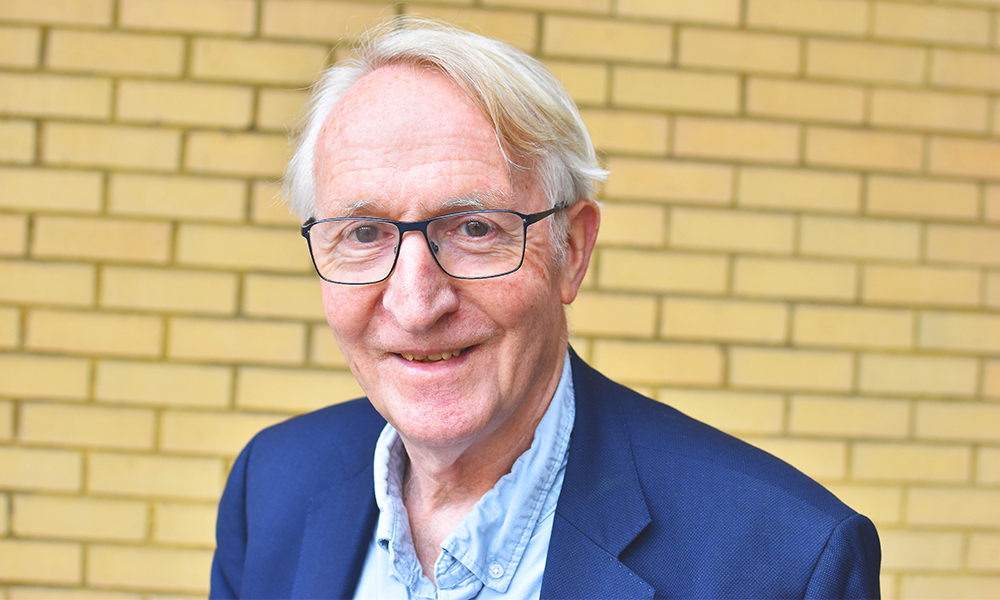 Image shows Planet Education Networks director Professor Cedric Bell, a man with white hair and glasses wearing a blue suit