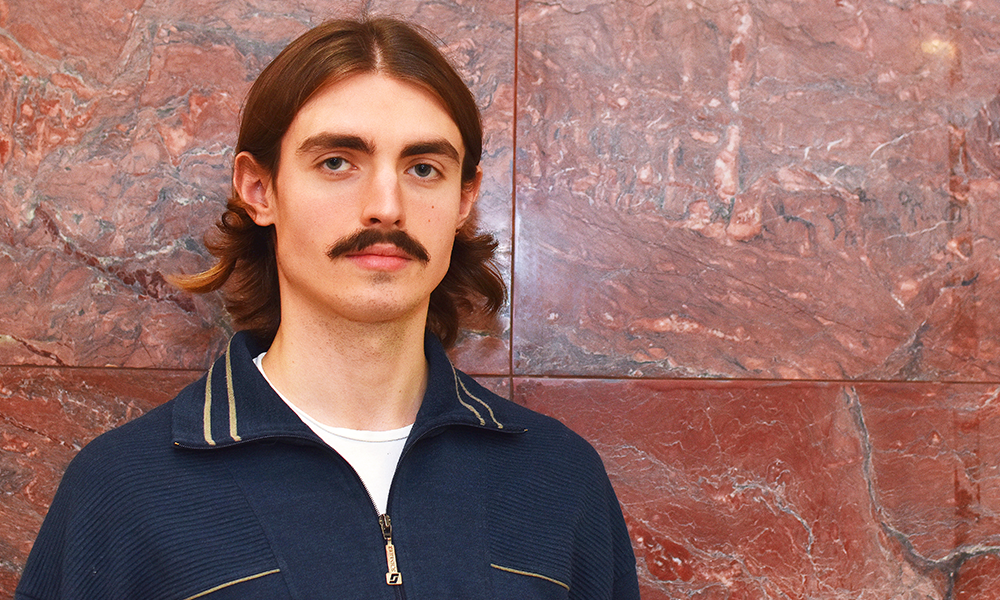 Image shows W'air Sneaker Laundry operations manager Oliver Grout, a man with long brown hair and a moustache in a blue top