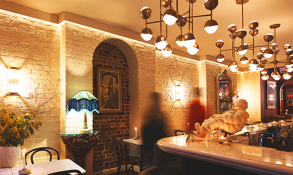 Image shows the interior of Fleurie in Bermondsey Street, a warmly lit wine bar with white walls