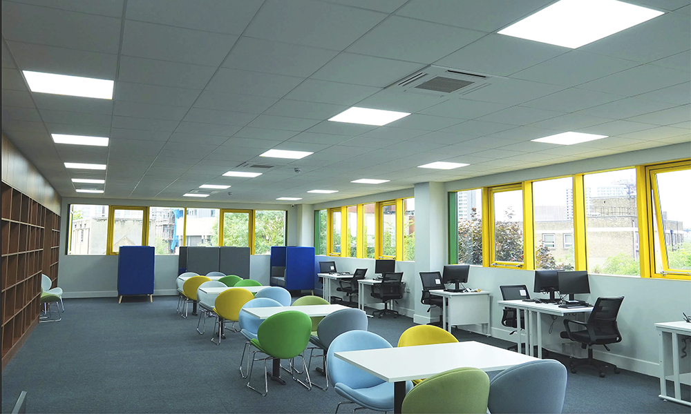 Image shows Willaiam College's library with shelves, seating and computers for students to use