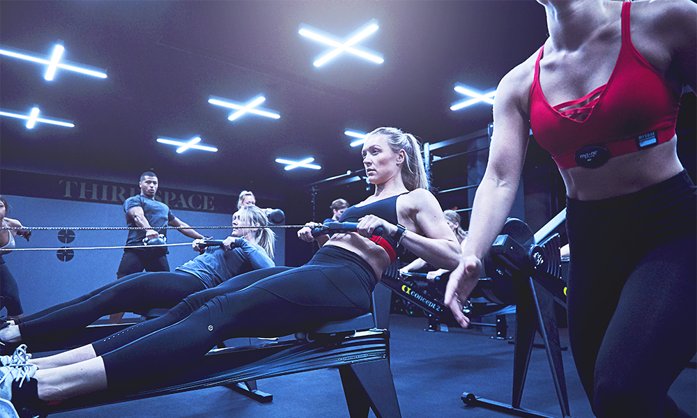 
The Canary Wharf and Wood Wharf clubs offer more than 300 classes each week – image shows members engaged in a Formula 3 class at Canary Wharf using weights and rowing machines