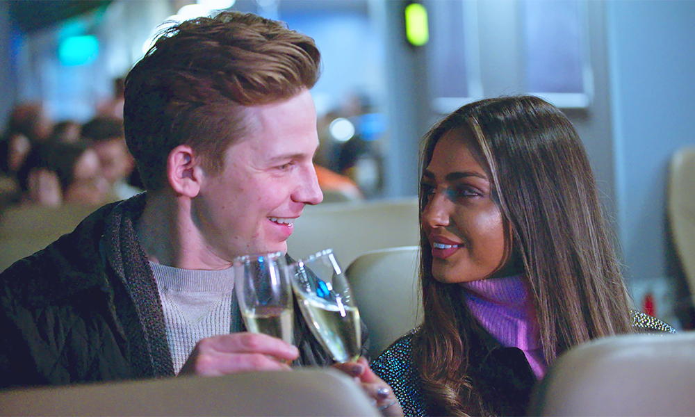 Image shows a couple toasting with Champagne on board Uber Boat By Thames Clippers