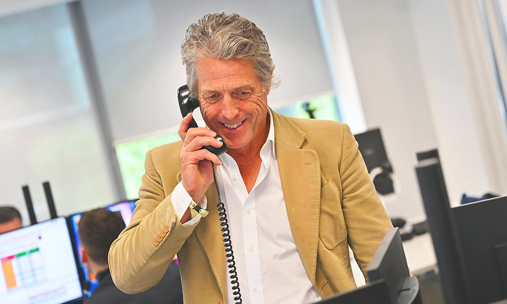 Hugh Grant takes a call at BGC Group's Charity Day as an ambassador for the Press Justice Project - Image 
by Dave Benett/Getty Images for BGC Group
