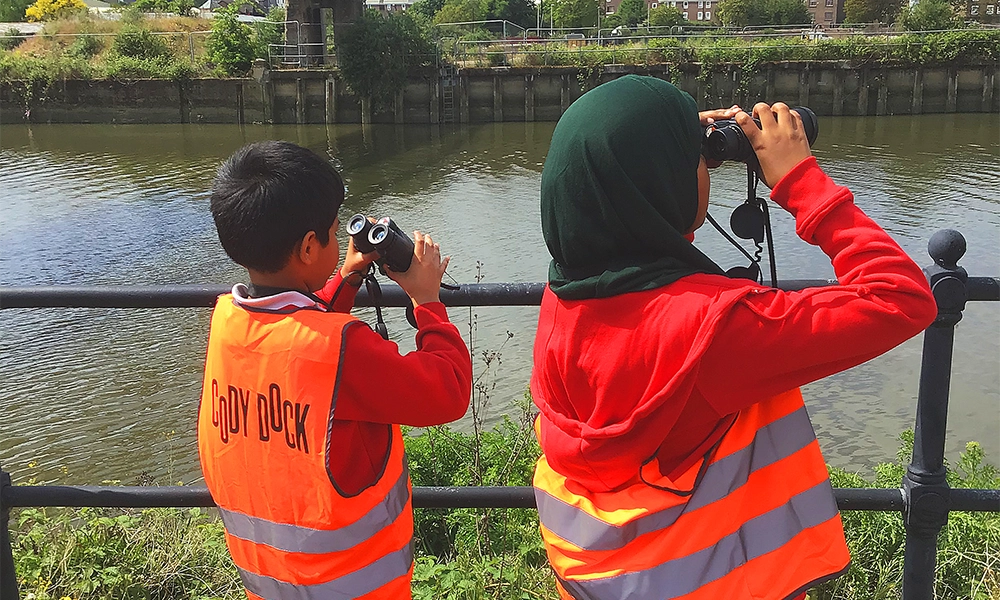 Children survey the River Lea on a visit to Cody Dock as part of the River Of Hope project - image supplied by Thames Festival Trust