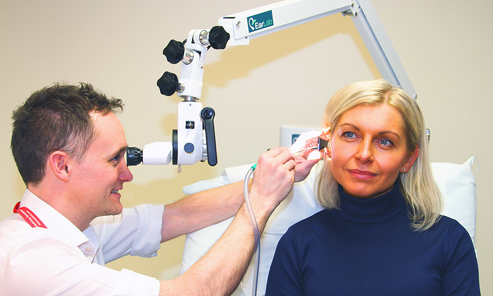 EarLab's David Walker clears a patient's ears using micro-suctioning guided by a surgical microscope - image supplied by EarLab