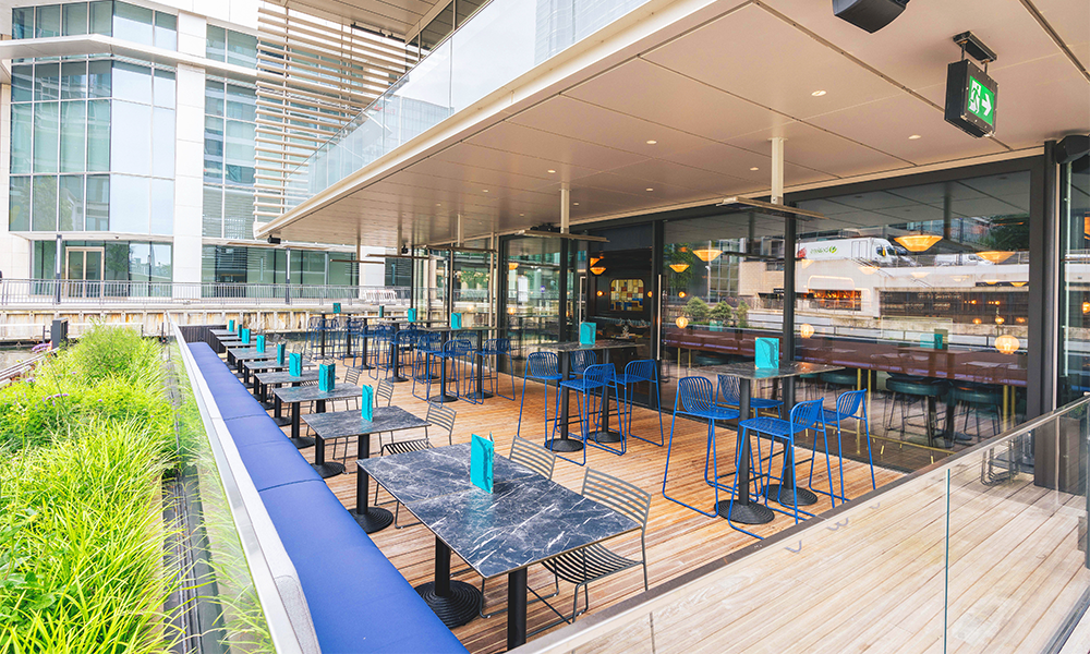 The venue's bar on its lower level boasts a terrace on the water - image supplied by Hawksmoor